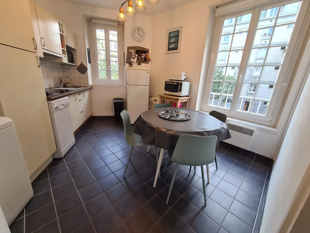 La cuisine–salle à manger avec table ronde et grande fenêtre