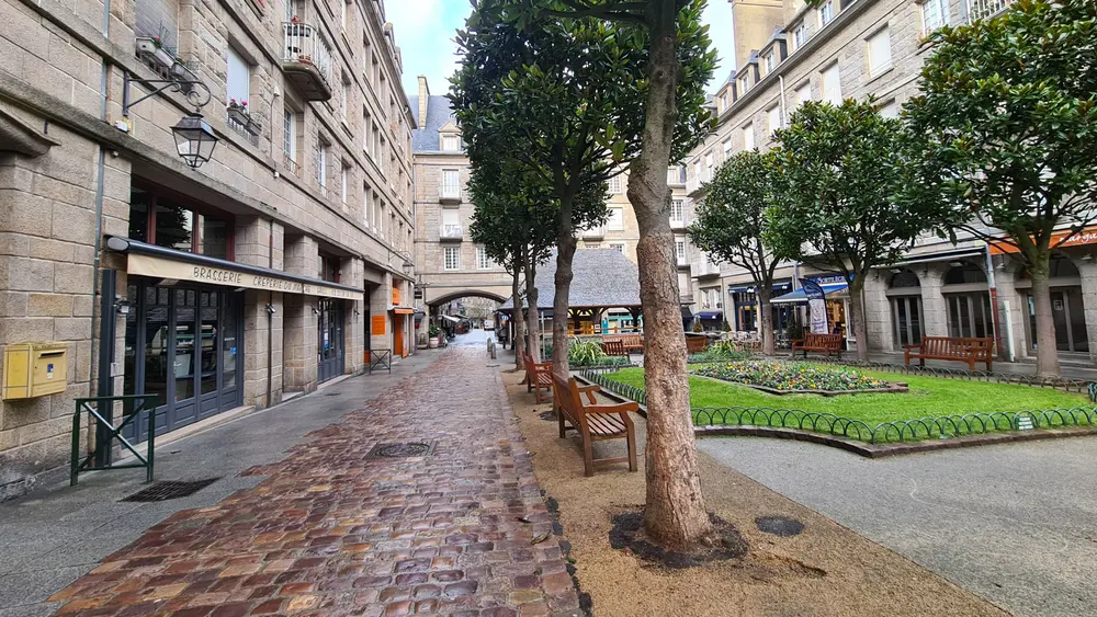 La rue pavée et le square au pied de l'immeuble