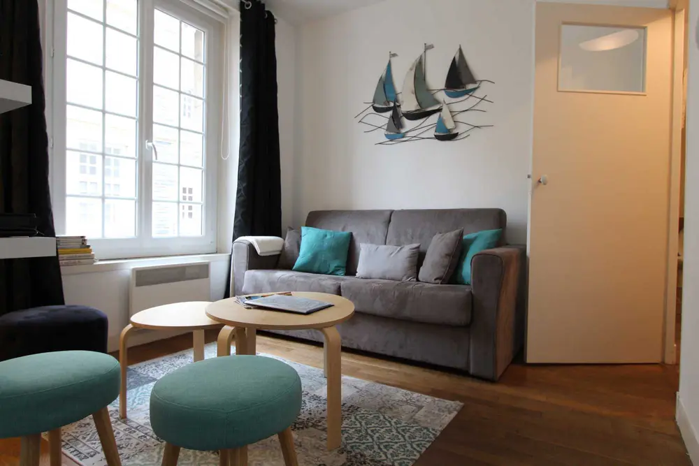 Le coin salon, ses poufs turquoise et ses voiliers au mur